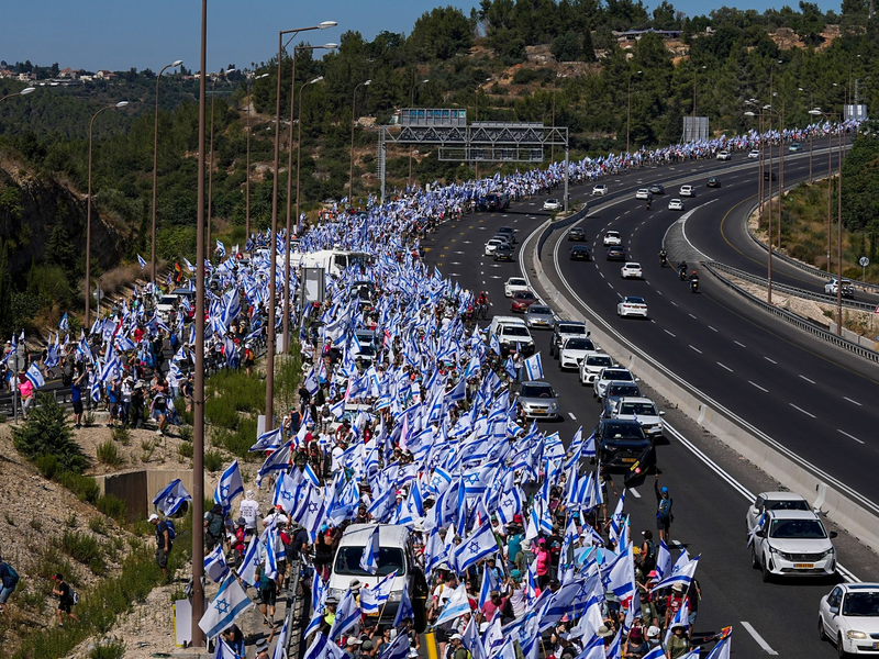 Angehörige und Unterstützer der israelischen Geiseln, die im Gazastreifen von der Hamas festgehalten werden, blockieren in Tel Aviv eine Straße und fordern ihre Freilassung. - Foto: Ohad Zwigenberg/AP/dpa