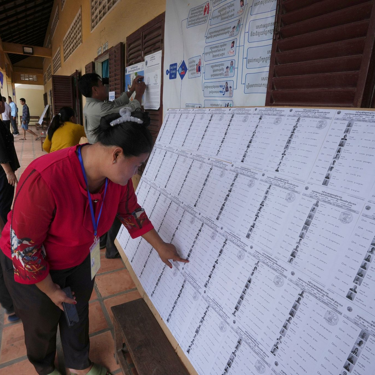 Bewohner von Phnom Penh sehen sich vor der Stimmabgabe in einem Wahllokal eine Registrierungsliste an. - Foto: Heng Sinith/AP