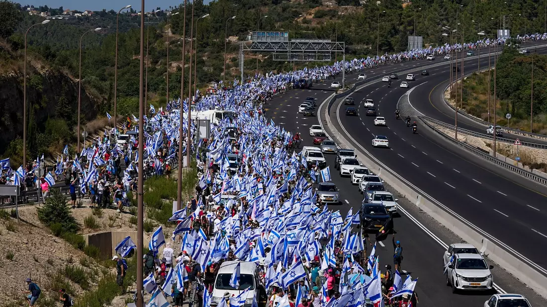 Tausende israelische Demonstranten marschieren entlang einer Autobahn, um gegen die geplante Justizreform der Regierung zu protestieren. - Bild: Ohad Zwigenberg/AP/dpa