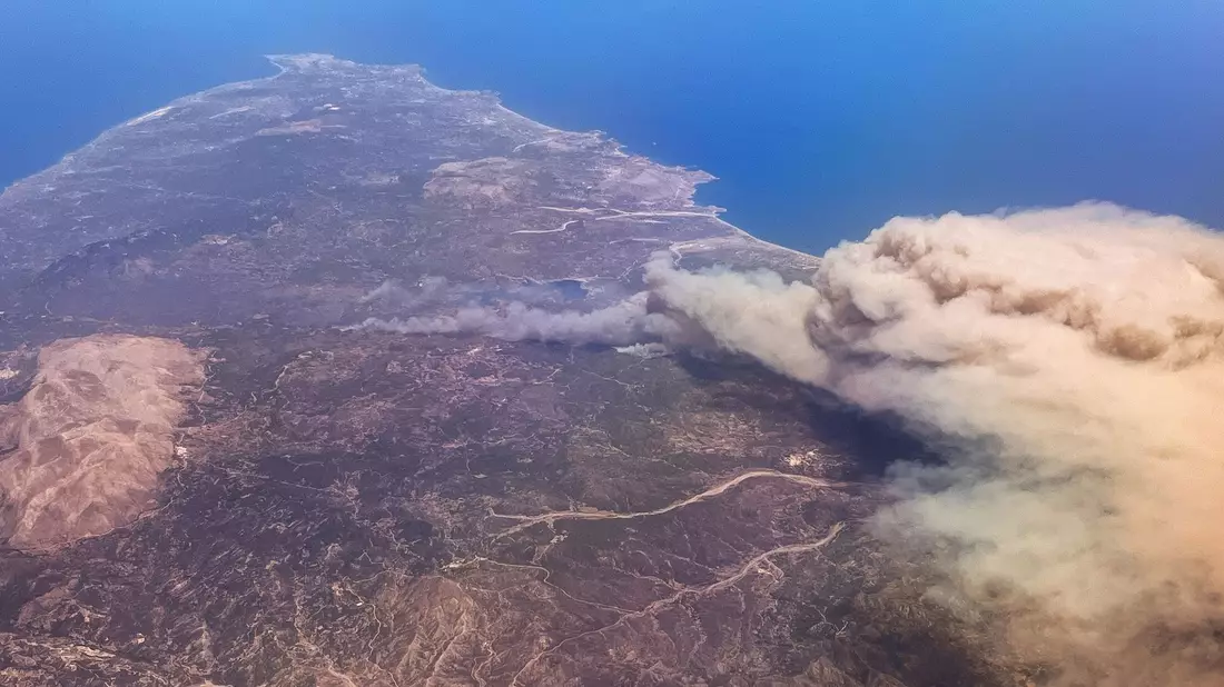 Rauchschwaden hängen über der griechischen Insel Rhodos. - Bild: Christophe Gateau/dpa