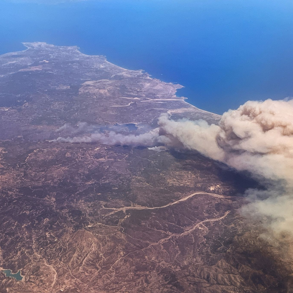 Rauchschwaden hängen über der griechischen Insel Rhodos. - Foto: Christophe Gateau/dpa