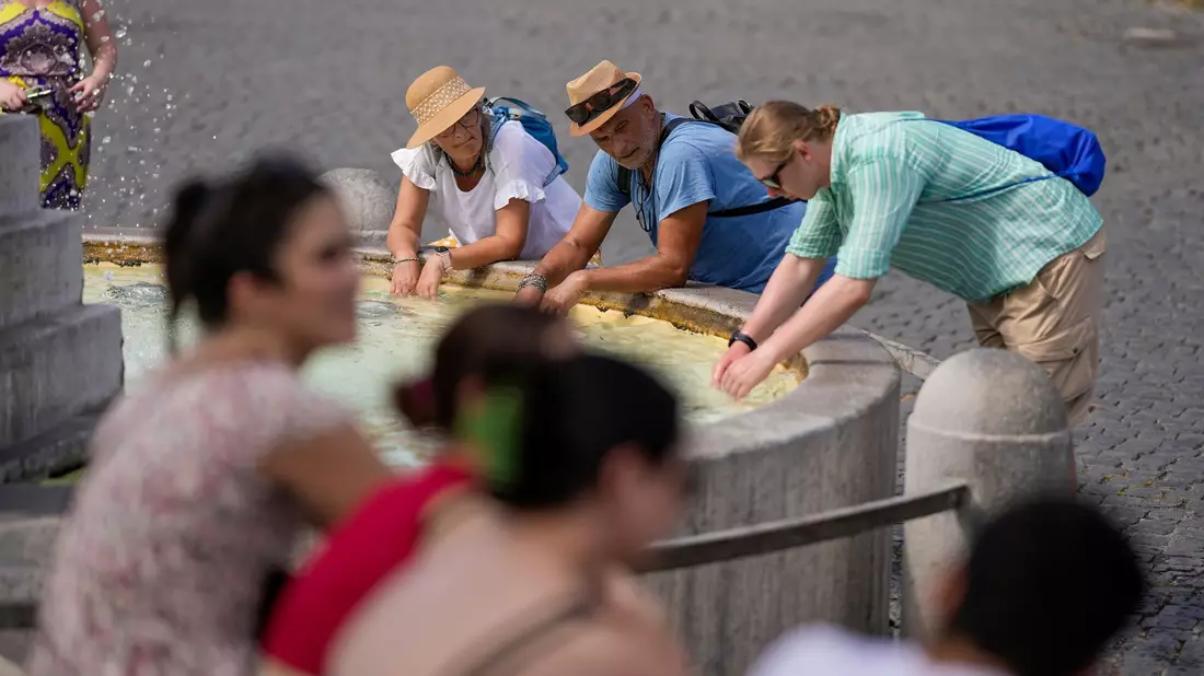 Eine Erfrischen am Brunnen in Rom gegen die hohen Temperaturen: Eine intensive Hitzewelle hat Italien erreicht. - Bild: Andrew Medichini/AP