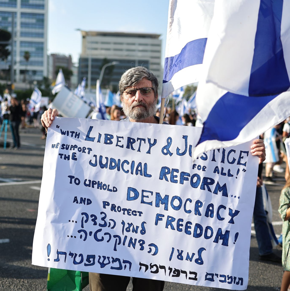 Dieser Demonstrant in Tel Aviv gehört zu den Unterstützern des Gesetzesvorhabens. - Foto: Ilia Yefimovich/dpa