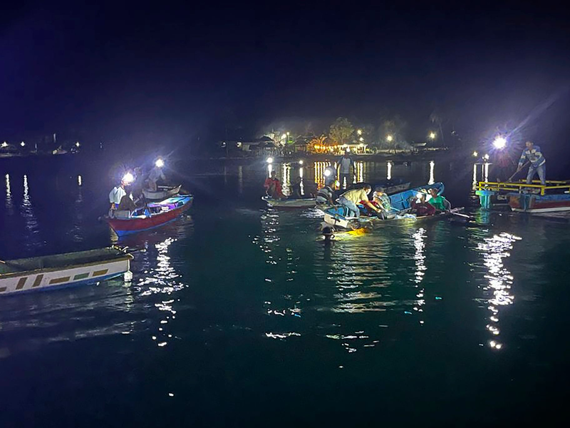 Mitarbeiter der Nationalen Such- und Rettungsbehörde und Anwohner suchen nach Überlebenden. - Foto: Uncredited/BASARNAS/AP/dpa