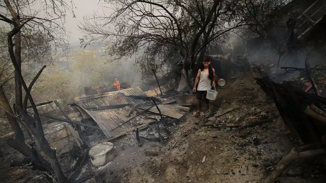 Ein Mann geht an einem Haus vorbei, das bei einem Waldbrand in der algerischen Provinz Bouira niedergebrannt ist. - Bild: XinHua/dpa