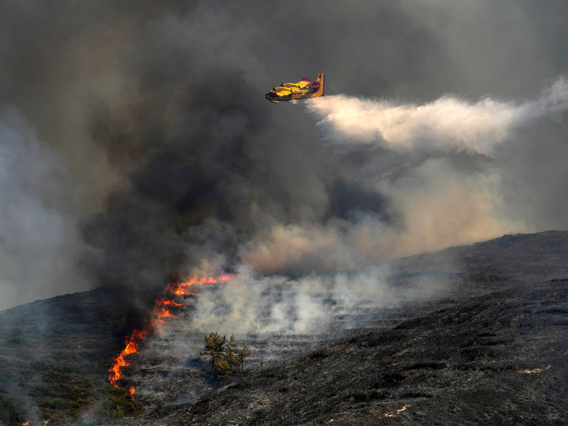 Löschflugzeug im Einsatz gegen die Flammen in Griechenland (Symbolbild). - Foto: Petros Giannakouris/AP/dpa