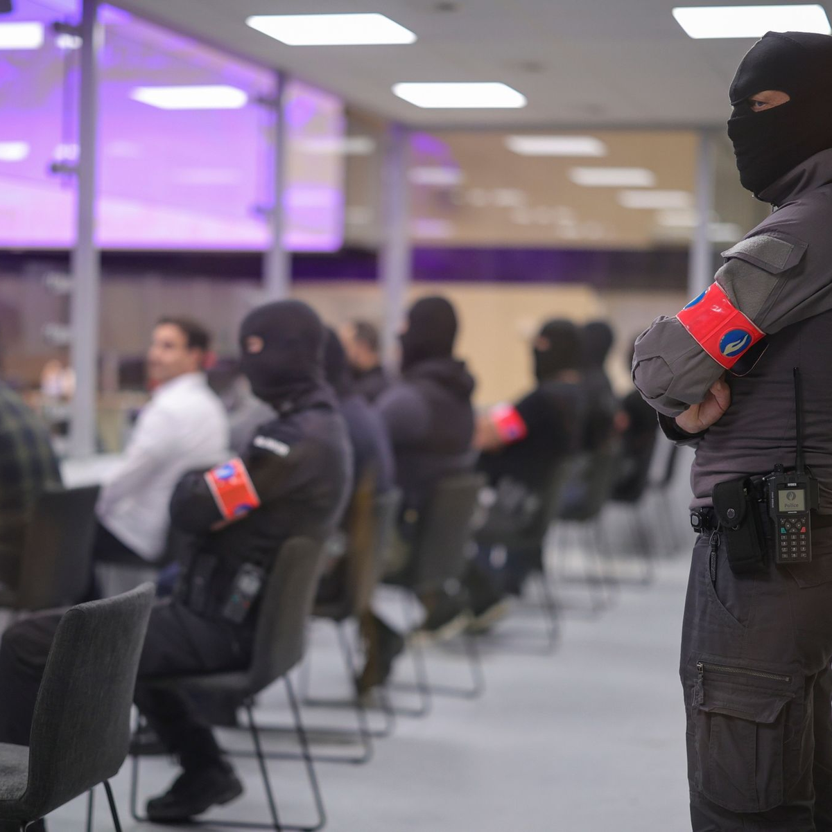 Sicherheitsbeamte im Gerichtssaal. Im Prozess um die islamistischen Anschläge 2016 in Brüssel haben die Geschworenen mehrere der zehn Angeklagten des terroristischen Mordes schuldig gesprochen. - Foto: Olivier Matthys/Pool EPA/AP/dpa