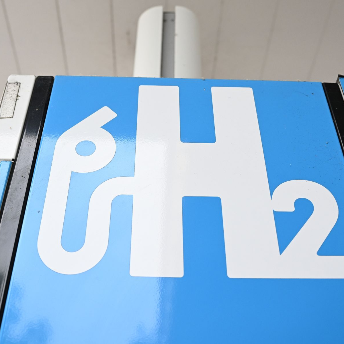 Ein Wasserstoff-Logo an einer Wasserstoff-Tankstelle für Autos. - Foto: Bernd Weißbrod/dpa