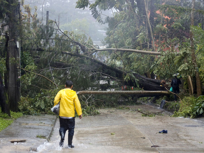 Ein Polizist inspiziert einen durch den Taifun «Doksuri» verursachten Erdrutsch in einem Wohngebiet in Baguio City. - Foto: Uncredited/AP
