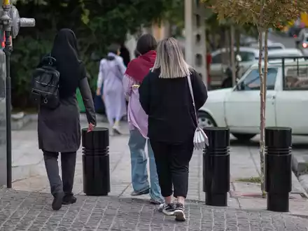 Eine Frau läuft im Juli 2023 mit offenen Haaren durch Teheran. Vor mehr als einem Jahr hatte der Tod der jungen Kurdin Jina Mahsa Amini die bislang schwersten Proteste in der Geschichte der Islamischen Republik ausgelöst. Viele Frauen zeigten sich daraufhin ohne Kopftuch in der Öffentlichkeit. - Foto: Arne Bänsch/dpa