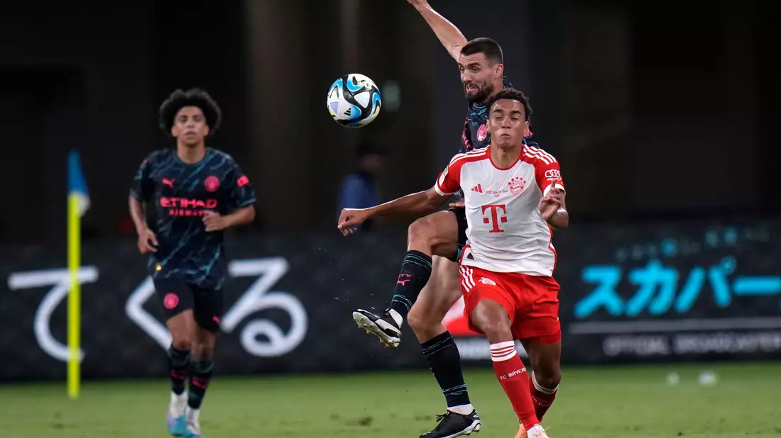 Die Bayern um Jamal Musiala (r) verloren den Test gegen Man City. - Bild: Shuji Kajiyama/AP/dpa