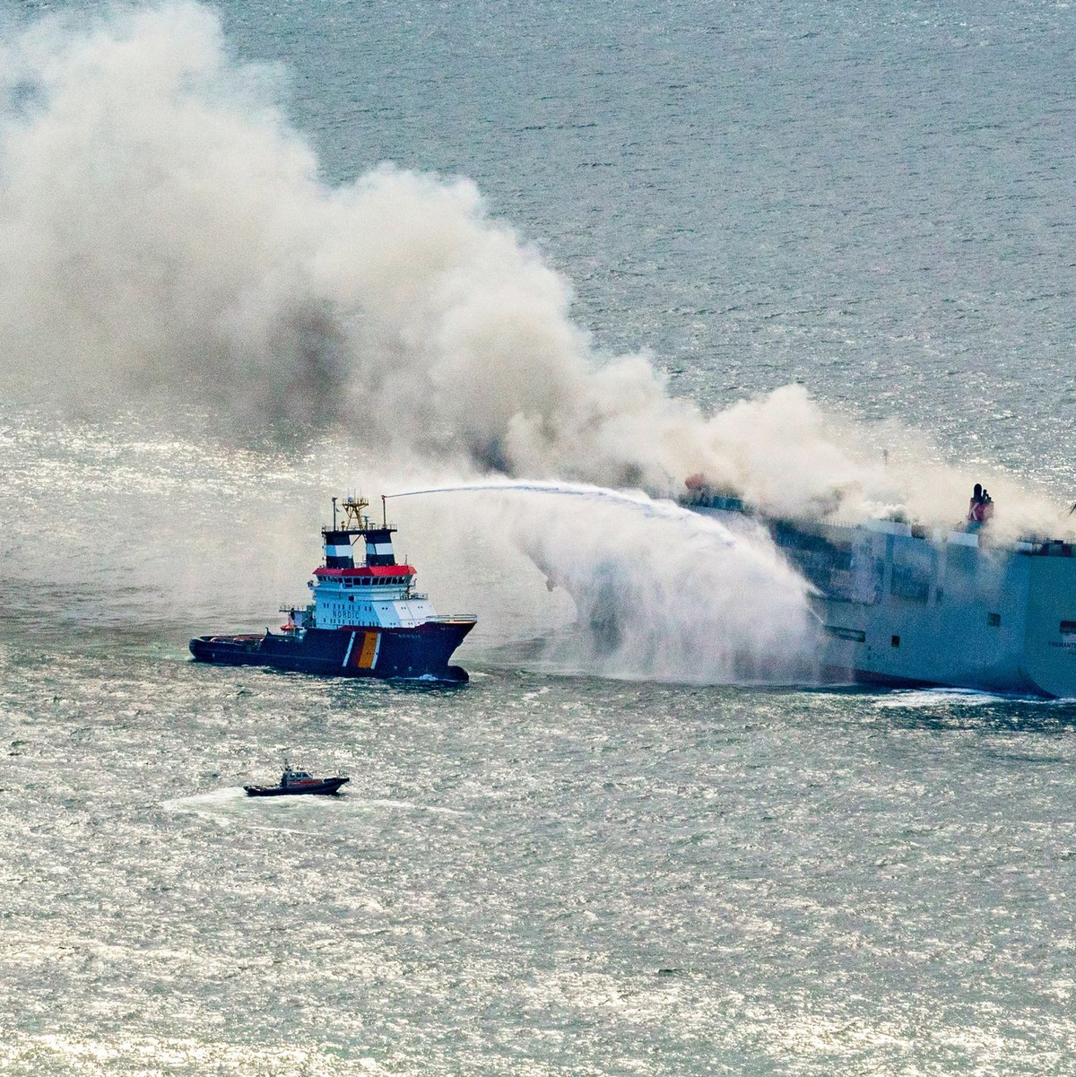 Der Frachter «Fremantle Highway» steht in Flammen. Ein Notschlepper (l) bekämpft das Feuer. - Foto: Herman IJsseling/FLYING FOCUS aerial photography/dpa