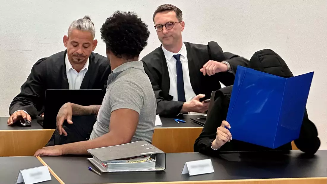 Eine ehemalige Justizvollzugsbeamtin (vorn r) und ein Häftling der Justizvollzugsanstalt Kaisheim (vorn l) sitzen auf der Anklagebank im Strafjustizzentrum Augsburg, im Hintergrund die Strafverteidiger. - Bild: Ulf Vogler/dpa