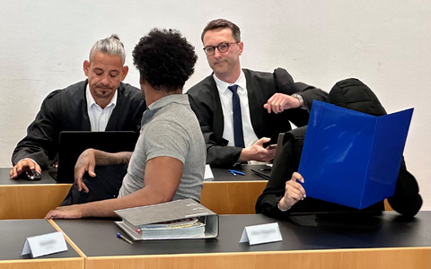 Eine ehemalige Justizvollzugsbeamtin (vorn r) und ein Häftling der Justizvollzugsanstalt Kaisheim (vorn l) sitzen auf der Anklagebank im Strafjustizzentrum Augsburg, im Hintergrund die Strafverteidiger. - Foto: Ulf Vogler/dpa