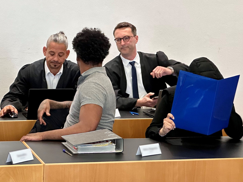 Eine ehemalige Justizvollzugsbeamtin (vorn r) und ein Häftling der Justizvollzugsanstalt Kaisheim (vorn l) sitzen auf der Anklagebank im Strafjustizzentrum Augsburg, im Hintergrund die Strafverteidiger. - Foto: Ulf Vogler/dpa