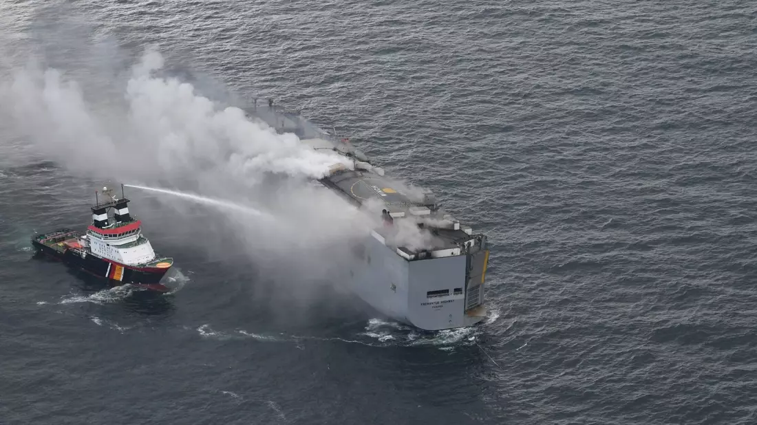 Der brennende Frachter «Fremantle Highway» in der Nordsee. Links im Bild ist der deutsche Notschlepper «Nordic» zu sehen, der das Feuer auf dem Frachter bekämpft. - Bild: Coast Guard Netherlands/dpa