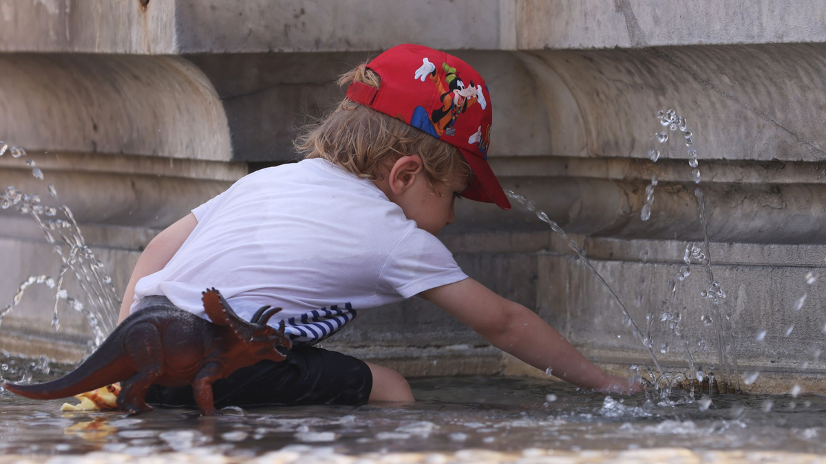 Ein Kind kühlt sich bei 38 Grad Celsius an einem Brunnen ab. - Foto: Gao Jing/XinHua/dpa