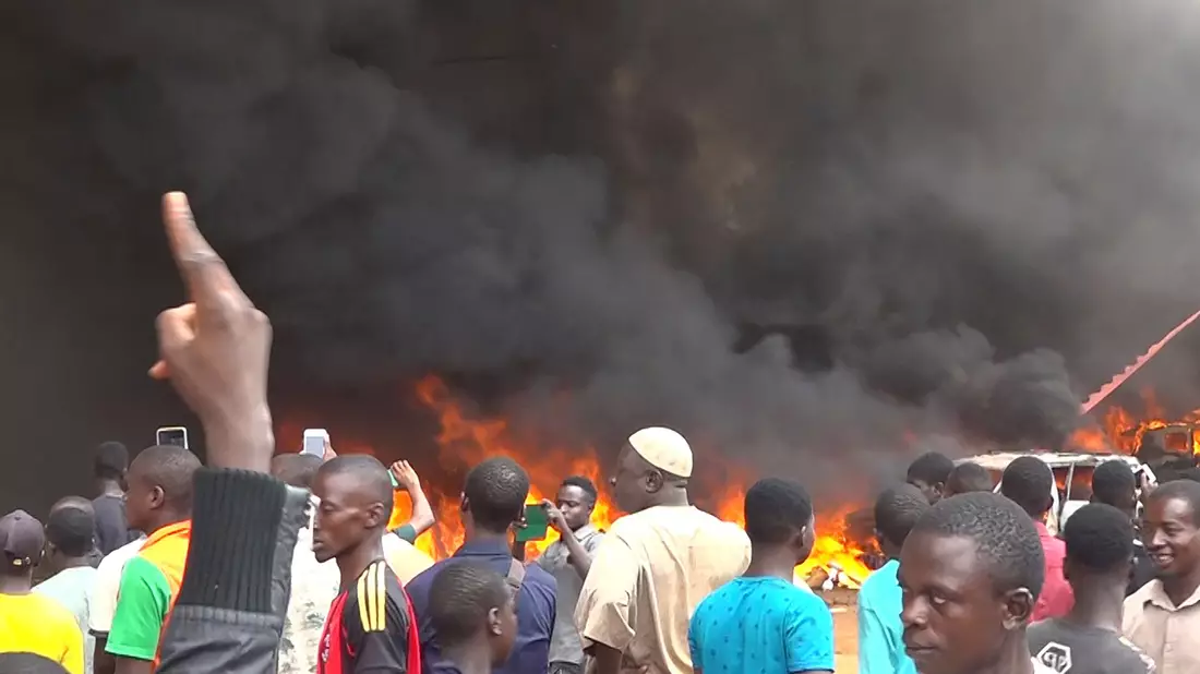 Anhänger meuternder Soldaten sind auf den Straßen von Nigers Hauptstadt Niamey unterwegs, das Hauptquartier der Regierungspartei steht in Flammen. Das Militär hat erklärt, die Forderung der Putschisten nach einem Ende der Amtszeit von Präsident Bazoum zu unterstützen. - Bild: Fatahoulaye Hassane Midou/AP/dpa