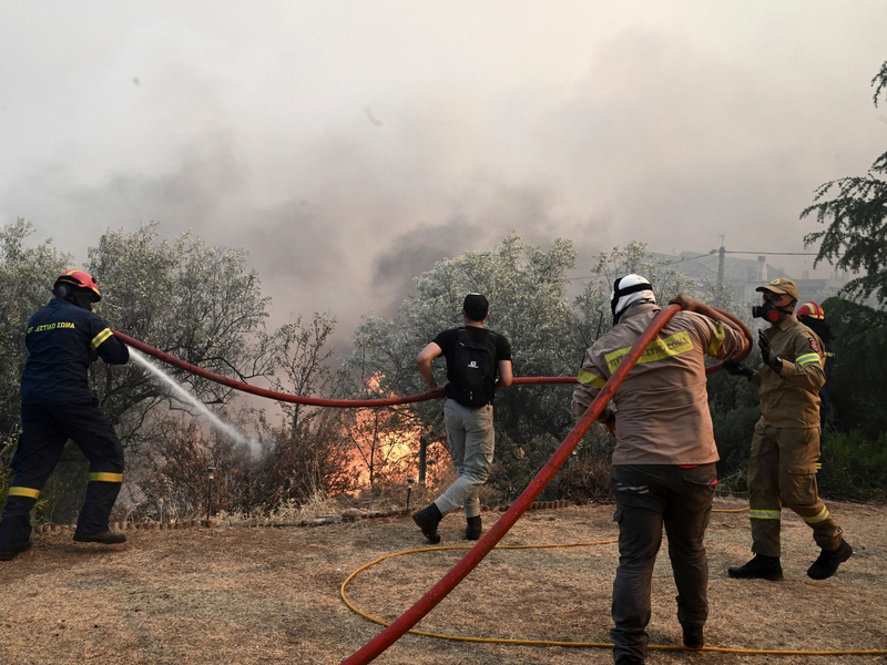 Feuerwehrleute und Freiwillige versuchen, einen Brand bei Nea Anchialos zu löschen. - Foto: Tatiana Bolari/Eurokinissi/AP/dpa