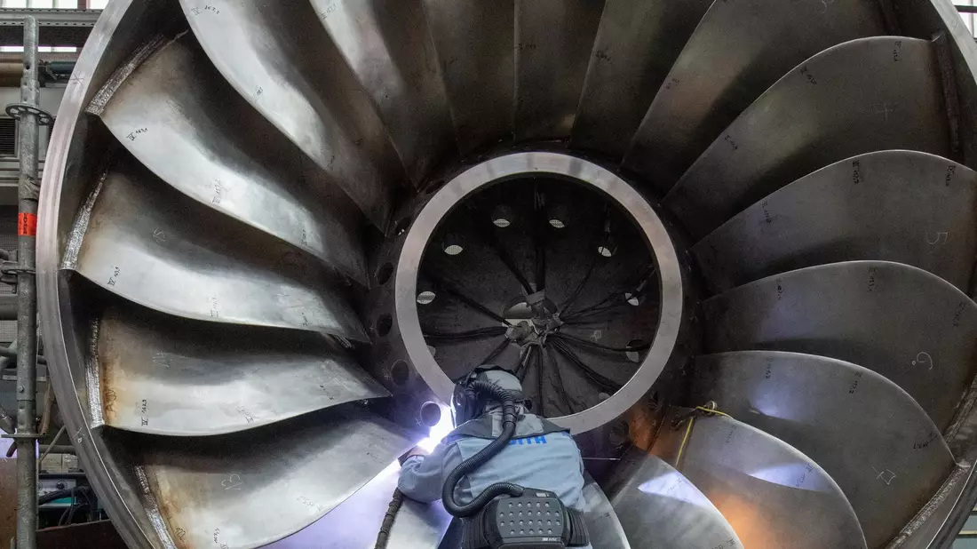 Ein Arbeiter an einer Wasserturbine. Die deutsche Wirtschaftsleistung könnte dem Internationalen Währungsfonds zufolge in diesem Jahr leicht sinken. - Bild: Stefan Puchner/dpa