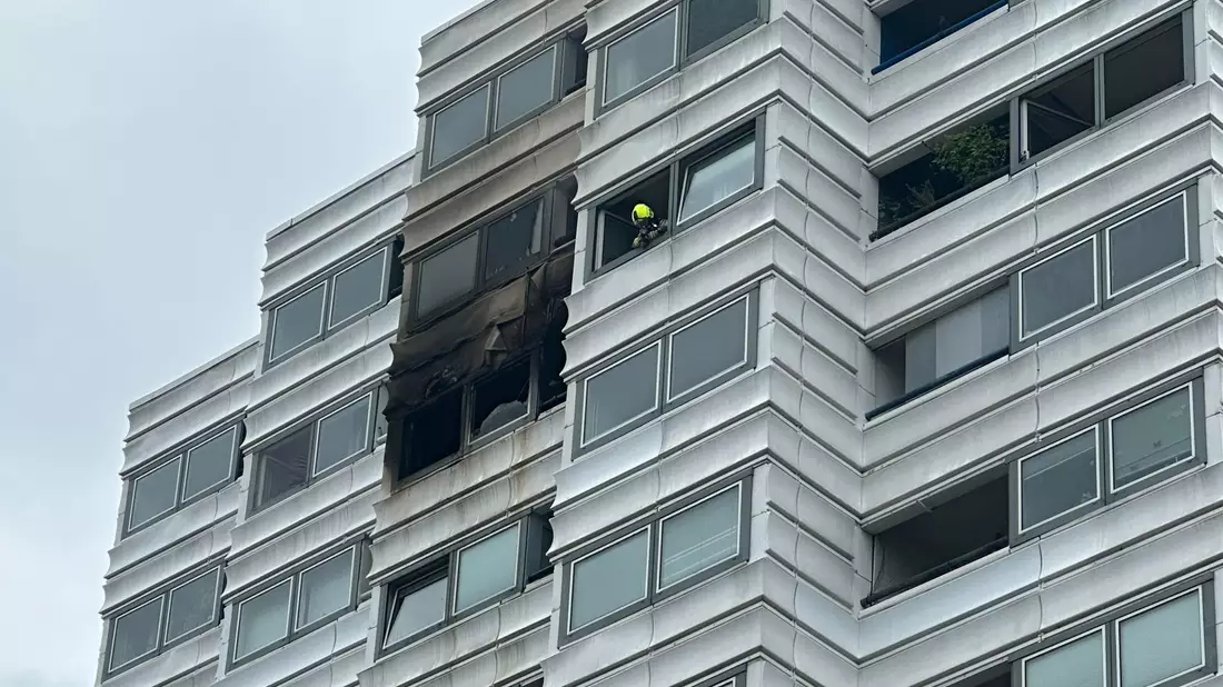 Einsatzkräfte vor dem Hochhaus in Berlin, in dem ein Feuer im zehnten Stock ausgebrochen war. - Bild: Annette Riedl/dpa