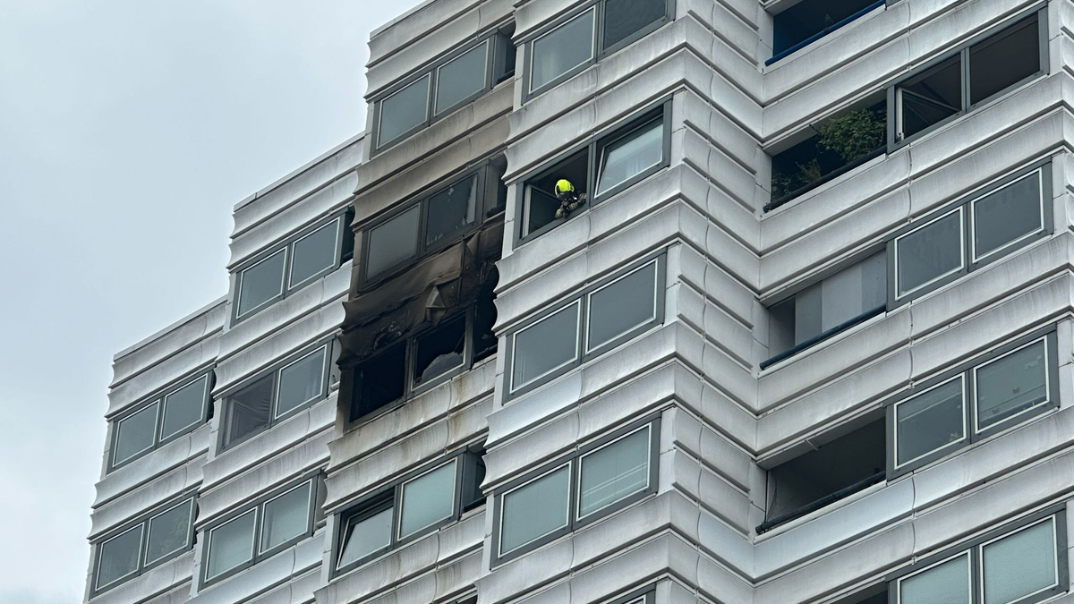 Einsatzkräfte vor dem Hochhaus in Berlin, in dem ein Feuer im zwölften Stock ausgebrochen war. - Foto: Annette Riedl/dpa