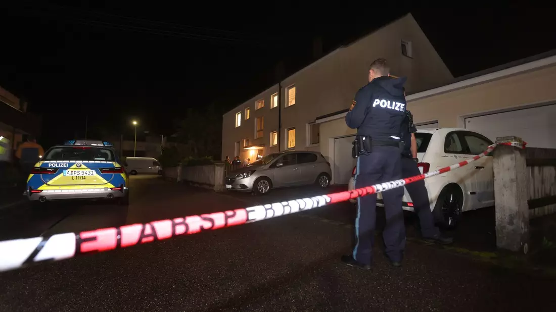 Polizisten am Tatort vor dem Haus in Langweid, in dem drei Menschen erschossen wurden. - Bild: Karl-Josef Hildenbrand/dpa