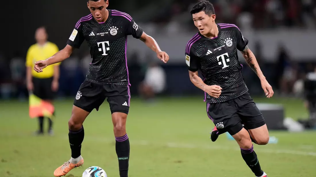 Jamal Musiala (l) und Min-Jae Kim beim Testspiel gegen Kawasaki Frontale. - Bild: Shuji Kajiyama/AP/dpa