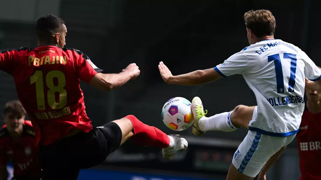 Wiesbadens Ivan Prtajin (l) und Magdeburgs Alexander Nollenberger kämpfen um den Ball. - Bild: Arne Dedert/dpa