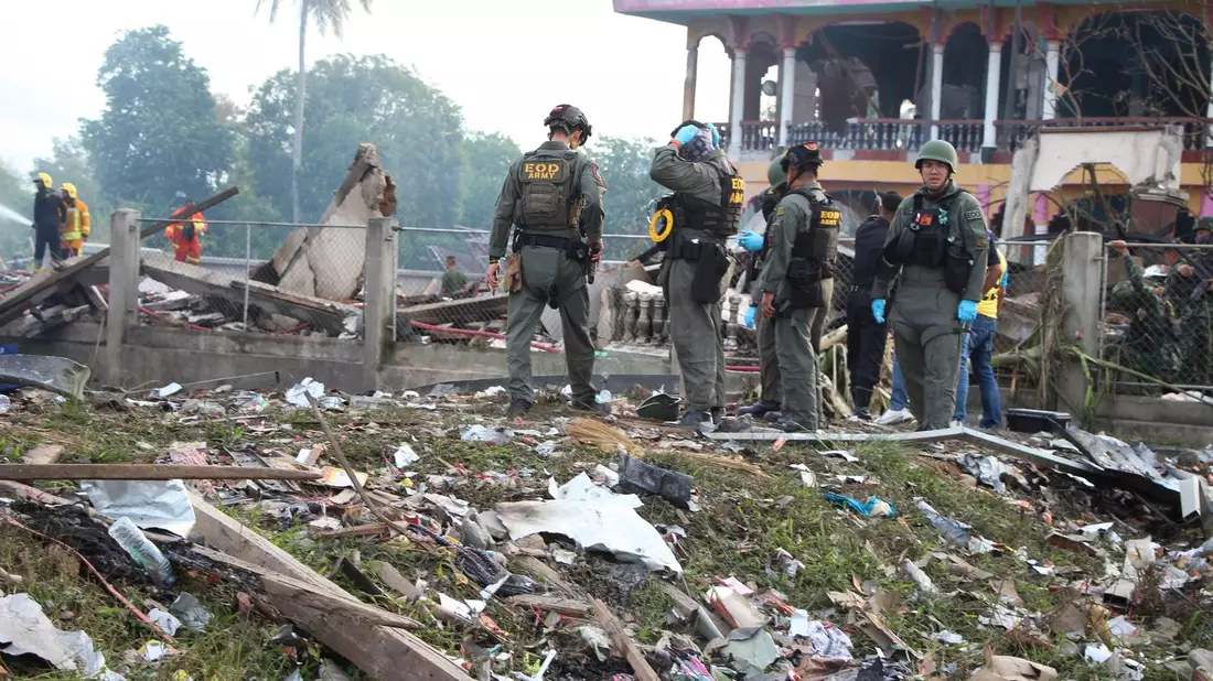 Einsatzkräfte des Kampfmittelräumdienstes untersuchen die Überreste eines durch eine Explosion zerstörten Gebäudes in Thailand. - Bild: Kriya Tehtani/AP