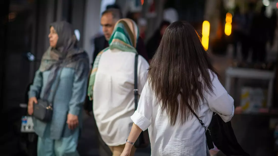 Eine Frau läuft mit offenen Haaren durch Teheran. - Bild: Arne Bänsch/dpa