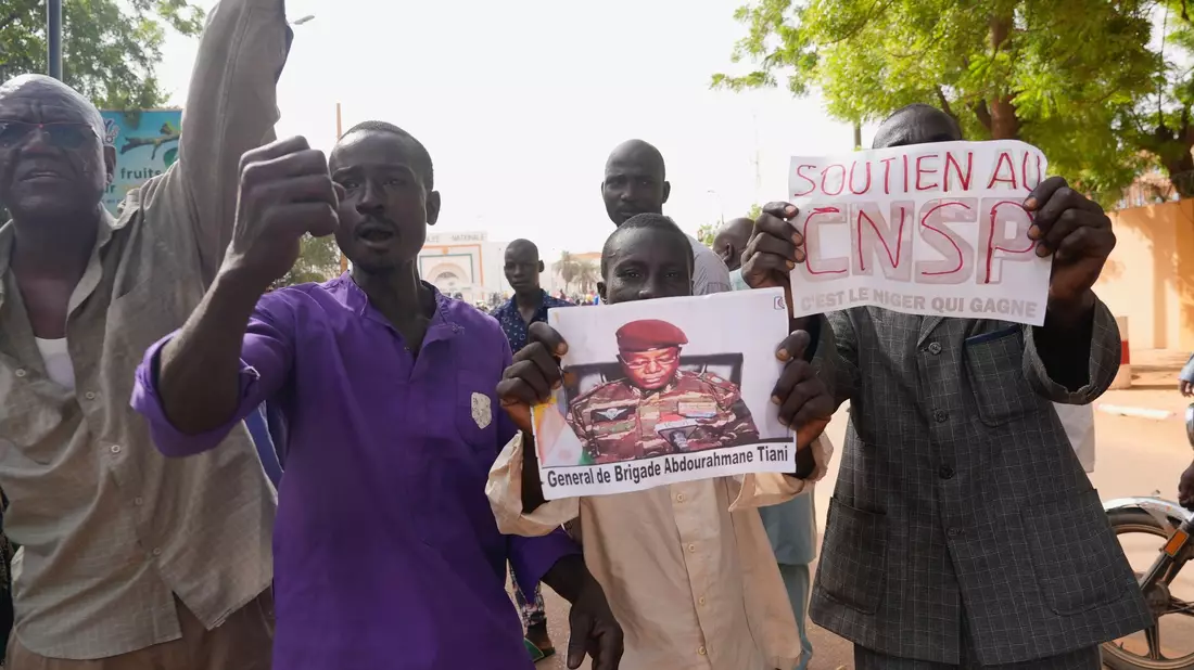 Menschen mit Plakaten des Putschisten General Omar Tchiani  
in Niamey. - Bild: Sam Mednick/AP/dpa