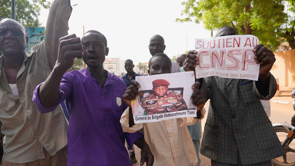 Menschen mit Plakaten des Putschisten General Omar Tchiani  
in Niamey. - Foto: Sam Mednick/AP/dpa