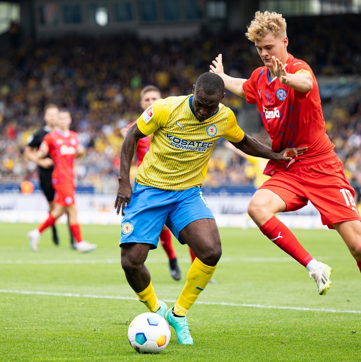 Der Braunschweiger Anthony Ujah (l) im Zweikampf mit dem Kieler Tom Rothe. - Foto: Michael Matthey/dpa