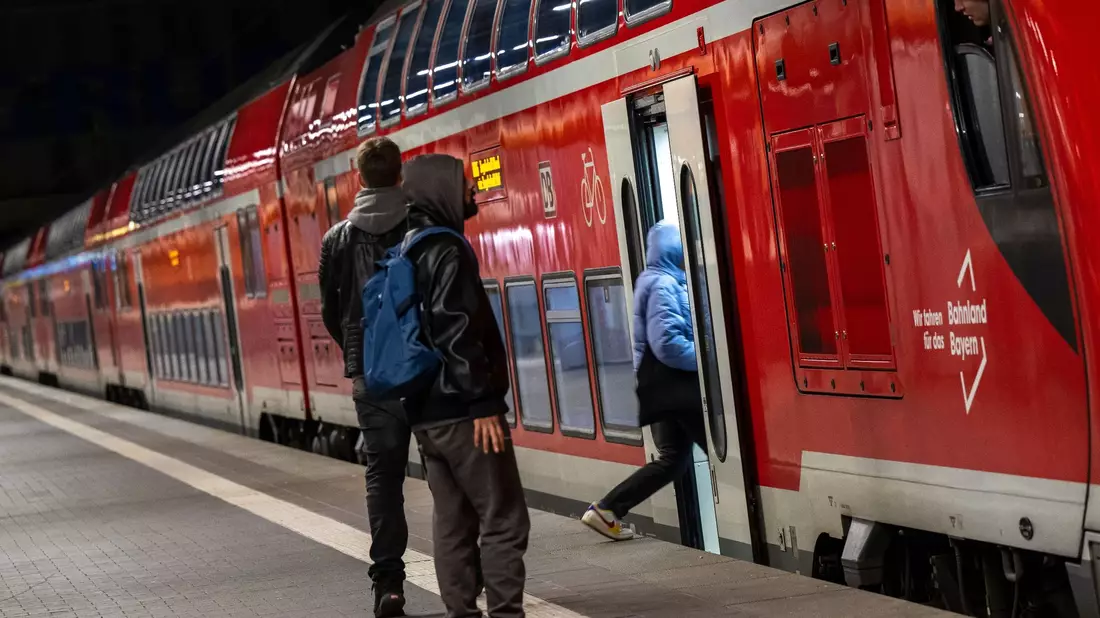Reisende im Hauptbahnhof München vor einer Regionalbahn. Die Mitglieder der Eisenbahn- und Verkehrsgewerkschaft (EVG) stimmen im August darüber ab, ob es zu einem Tarifabschluss mit der Deutschen Bahn kommt oder zu unbefristeten Streiks. - Bild: Peter Kneffel/dpa
