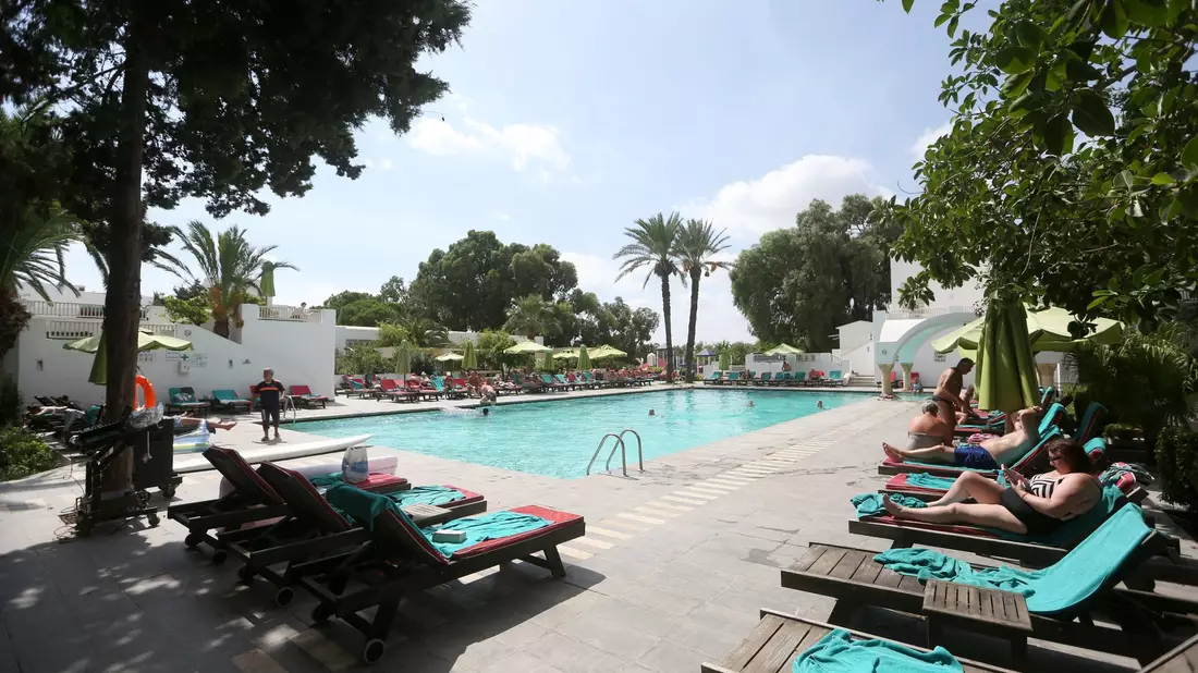 Urlauber entspannen am Swimmingpool eines Hotels in Tunesien. - Bild: Mohamed Krit/BELGA/dpa