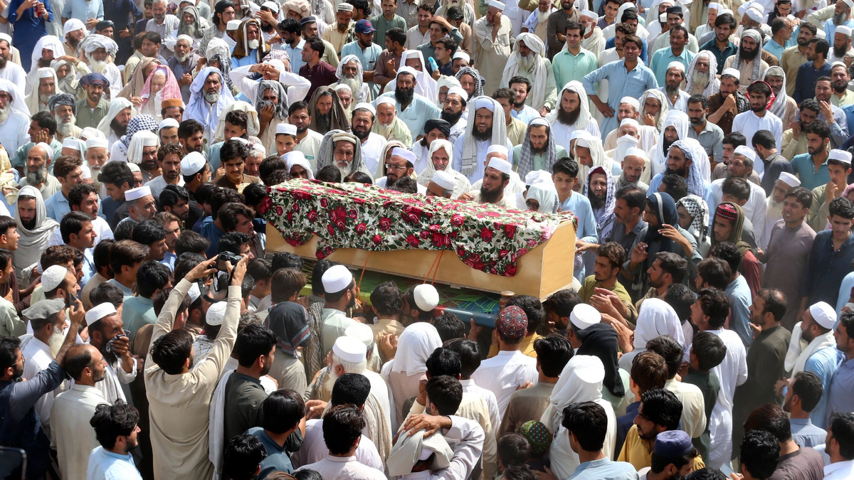 Trauernde nehmen in Bajur an der Beerdigung von Opfern der Bombenexplosion teil. - Foto: Mohammad Sajjad/AP/dpa