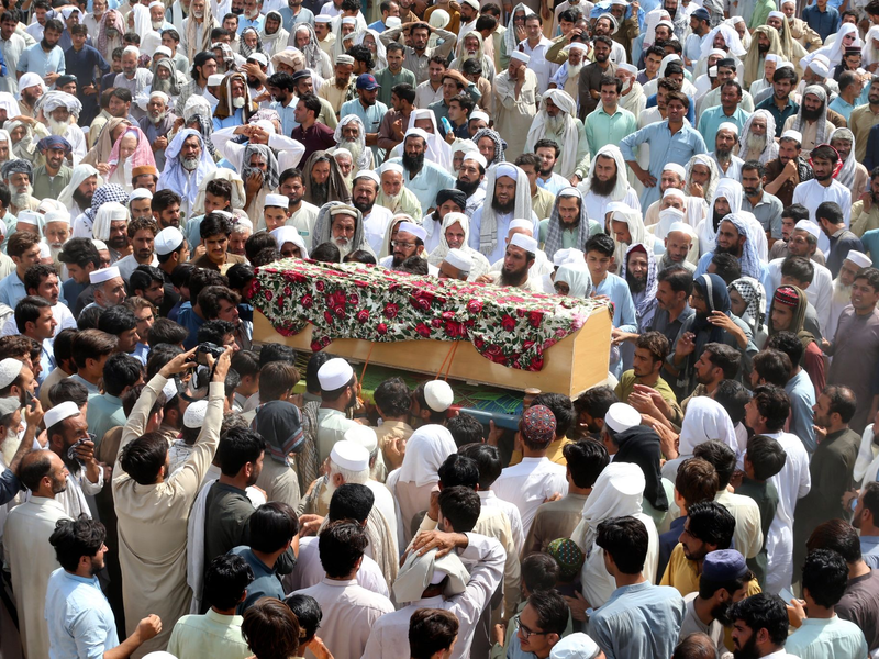 Trauernde nehmen in Bajur an der Beerdigung von Opfern der Bombenexplosion teil. - Foto: Mohammad Sajjad/AP/dpa