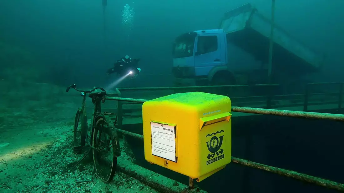 Ein gelber Briefkasten der Marke Eigenbau wurde im niedersächsischen Kreidesee in einer Tiefe von 19 Metern unter Normalnull angebracht. - Bild: Jens-Uwe Lamm/Tauchbasis Kreidesee/dpa