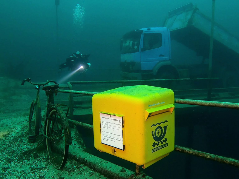Ein gelber Briefkasten der Marke Eigenbau wurde im niedersächsischen Kreidesee in einer Tiefe von 19 Metern unter Normalnull angebracht. - Foto: Jens-Uwe Lamm/Tauchbasis Kreidesee/dpa