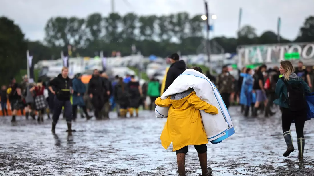 Auf den Wegen versinken die Festivalbesucher oft bis über die Knöchel im Matsch. - Bild: Christian Charisius/dpa
