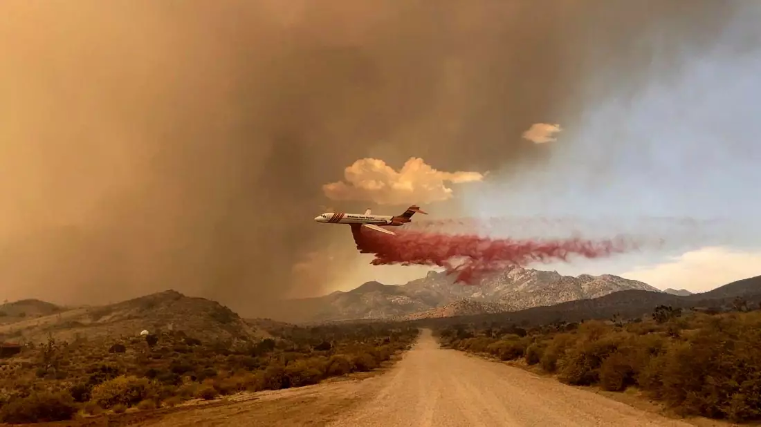 Ein Löschflugzeug ist über dem Mojave National Preserve im Einsatz, einem Schutzgebiet im US-Bundesstaat Kalifornien. - Bild: R. Almendinger/National Park Service Mojave National Preserve/AP/dpa