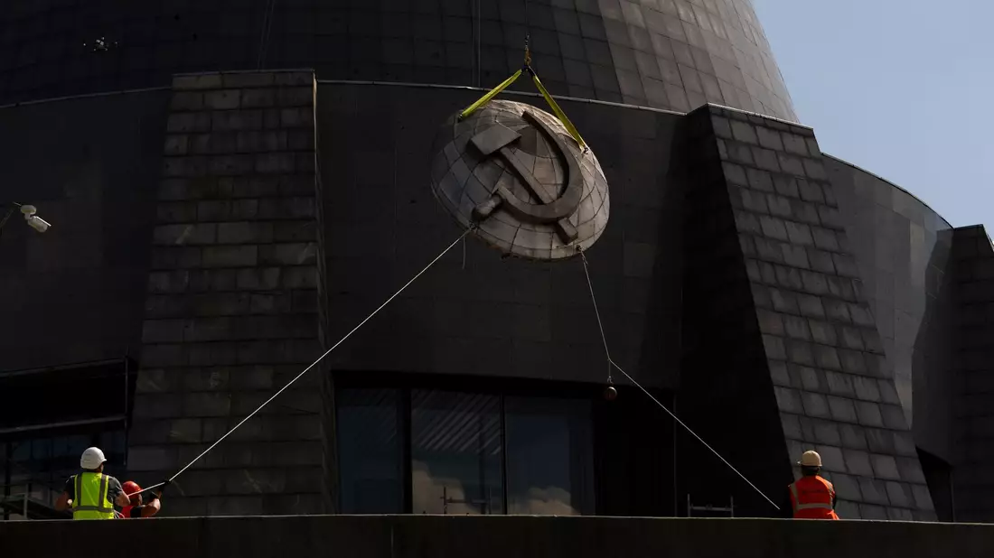 Arbeiter entfernen ein sowjetisches Emblem vom «Mutterlanddenkmal» in Kiew. Die Insignien werden durch ein ukrainisches Emblem ersetzt. - Bild: Jae C. Hong/AP/dpa