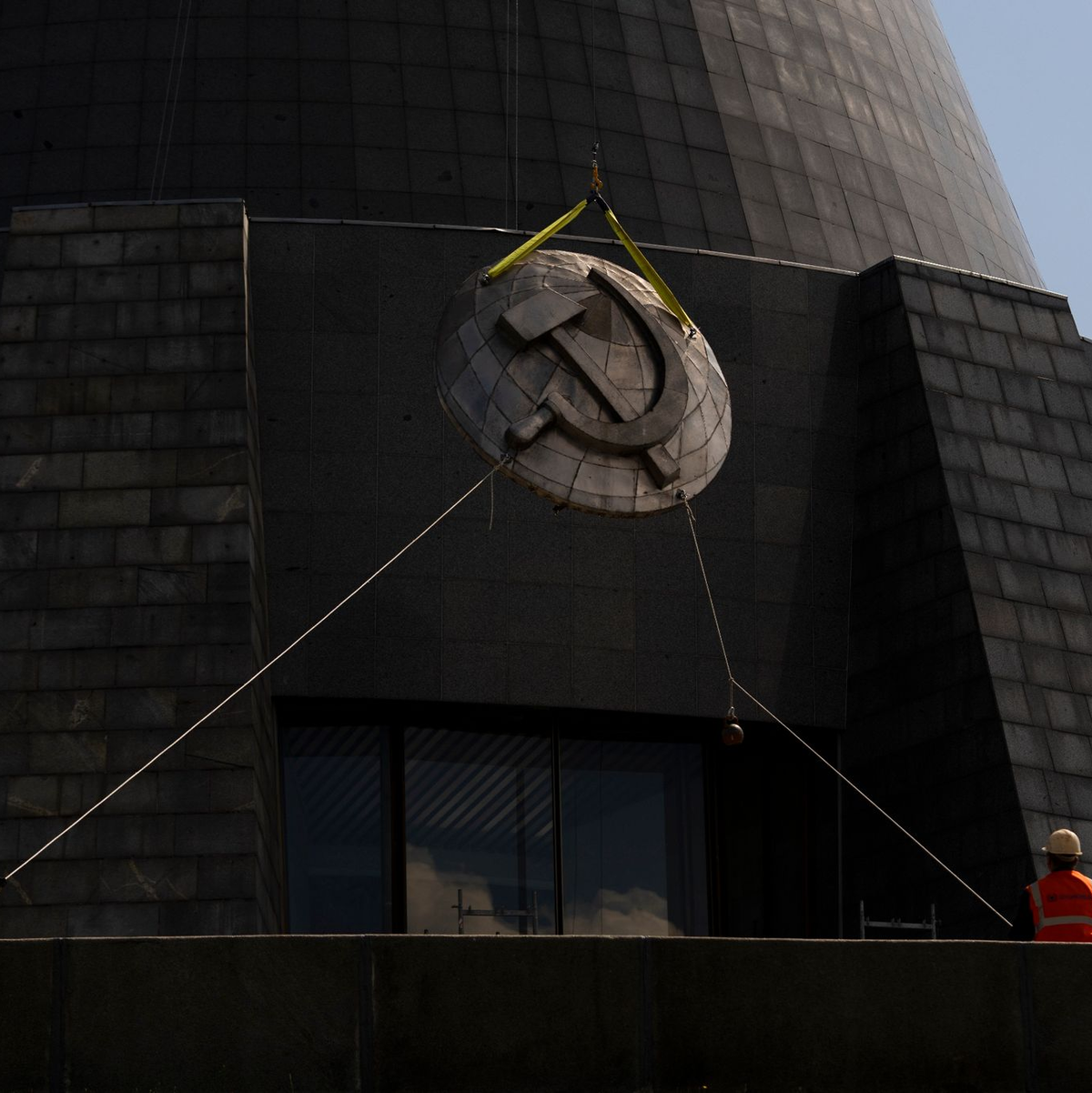 Arbeiter entfernen ein sowjetisches Emblem vom «Mutterlanddenkmal» in Kiew. Die Insignien werden durch ein ukrainisches Emblem ersetzt. - Foto: Jae C. Hong/AP/dpa