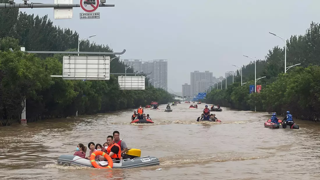 Mit Schlauchbooten werden Zivilisten südlich von Peking evakuiert. - Bild: Andy Wong/AP/dpa