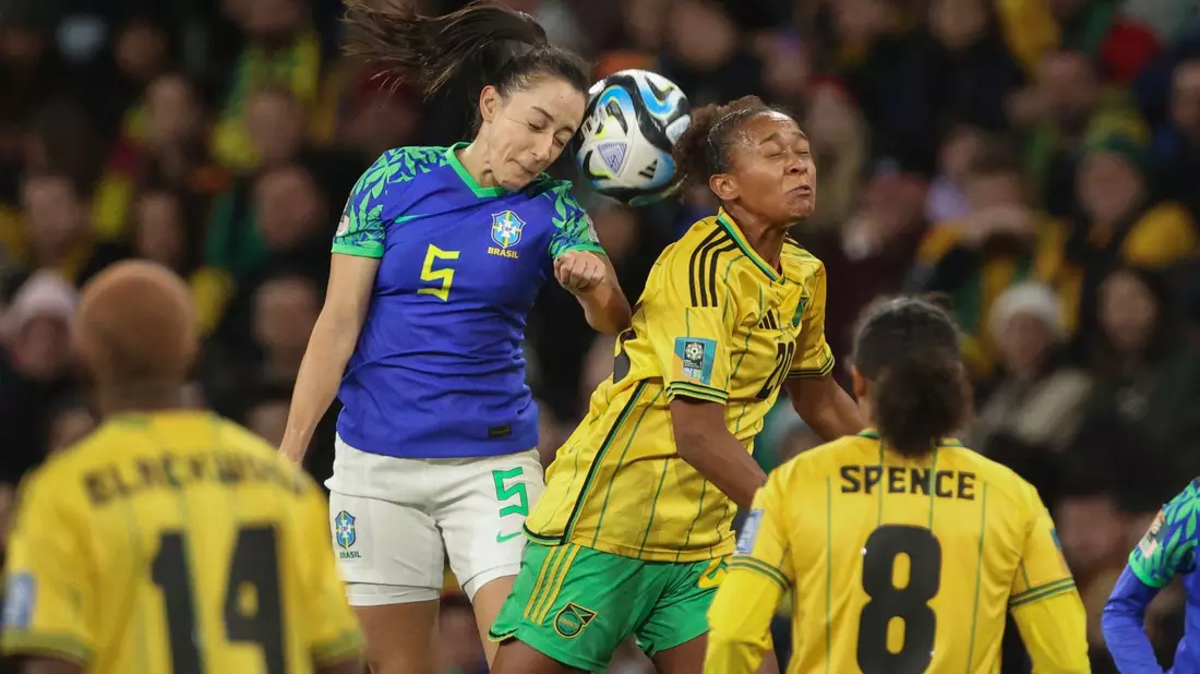 Die Brasilianerin Luana (l) und die Jamaikanerin Atlanta Primus (M) liefern sich ein Kopfballduell. - Bild: Hamish Blair/AP/dpa