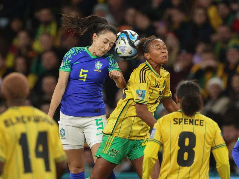 Die Brasilianerin Luana (l) und die Jamaikanerin Atlanta Primus (M) liefern sich ein Kopfballduell. - Foto: Hamish Blair/AP/dpa