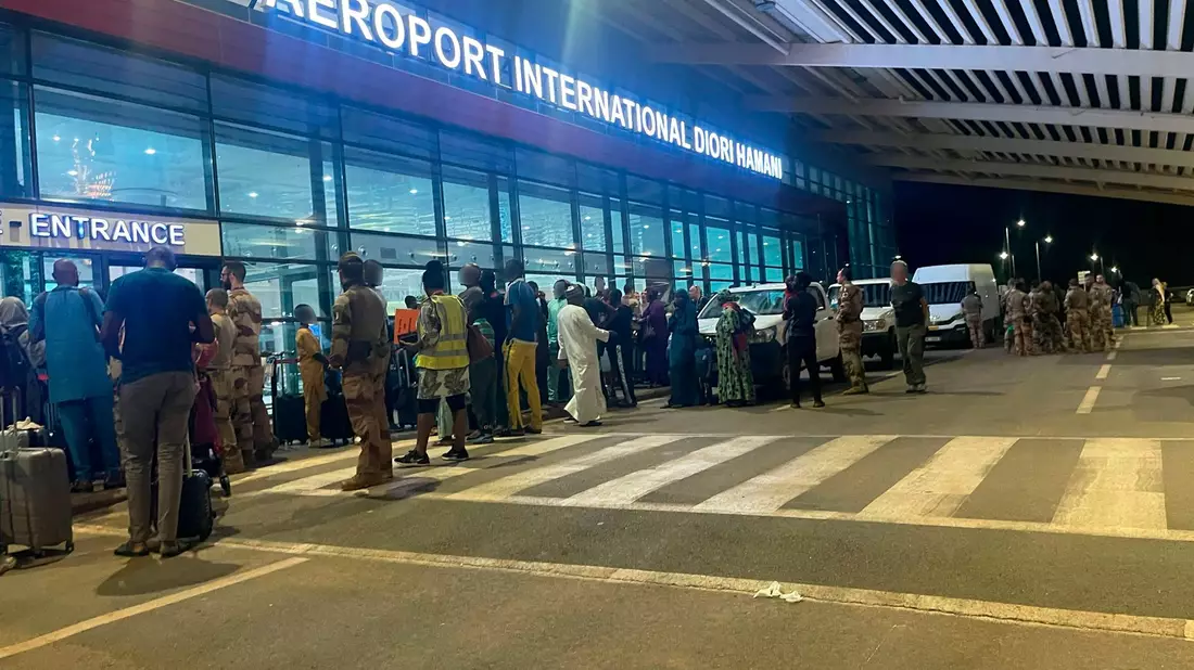Menschen sind vor dem dem internationalen Flughafen von Niamey zu sehen. Knapp eine Woche nach dem Militärputsch im Niger hat Frankreich mit der Evakuierung seiner Staatsbürger aus dem westafrikanischen Land begonnen. - Bild: Generalstab der französischen Armee/dpa