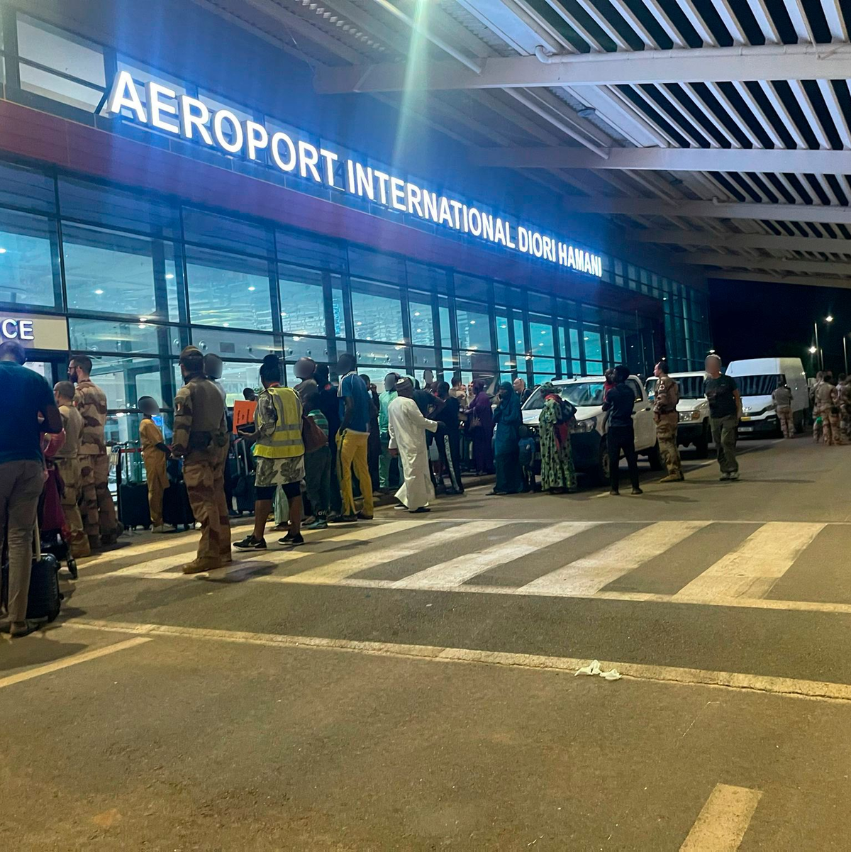 Menschen sind vor dem dem internationalen Flughafen von Niamey zu sehen. Knapp eine Woche nach dem Militärputsch im Niger hat Frankreich mit der Evakuierung seiner Staatsbürger aus dem westafrikanischen Land begonnen. - Foto: Generalstab der französischen Armee/dpa