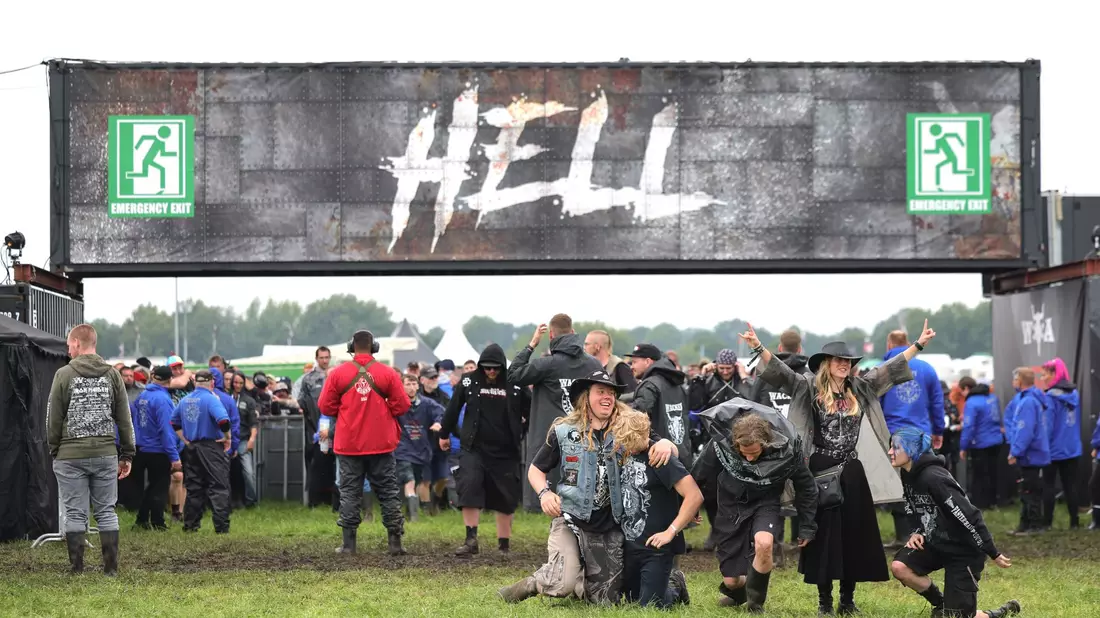 Metal-Fans freuen sich nach der Öffnung der Tore zum inneren Festivalgelände in Wacken. - Bild: Christian Charisius/dpa